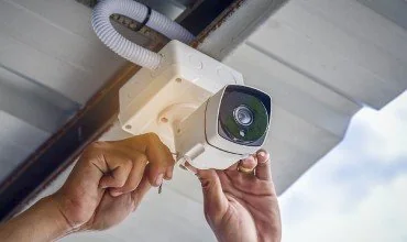 Technician installing a surveillance camera