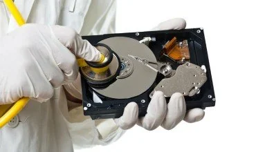 Technician handling a storage drive for data recovery